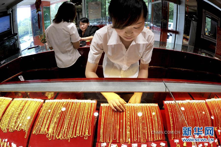 9月26日，浙江義烏一金店工作人員在整理上柜銷售的黃金飾品。隨著國際黃金市場風(fēng)云突變，國內(nèi)金價26日繼續(xù)大跌。與此同時，曾經(jīng)高高在上的鉑金價格也大幅下調(diào)，出現(xiàn)了黃金價格全面高于鉑金價格的罕見倒掛現(xiàn)象。26日，上海黃金交易所黃金Au99.95合約收盤價為每克327.95元，而鉑金Pt99.95合約收盤價僅為每克326.08元。