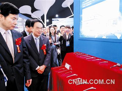 陳全訓在惠進才的陪同下參觀國際鈦博會企業(yè)展臺。