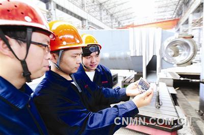 中信重工十九大代表劉新安的徒弟在工位上通過手機收看十九大開幕式實況。