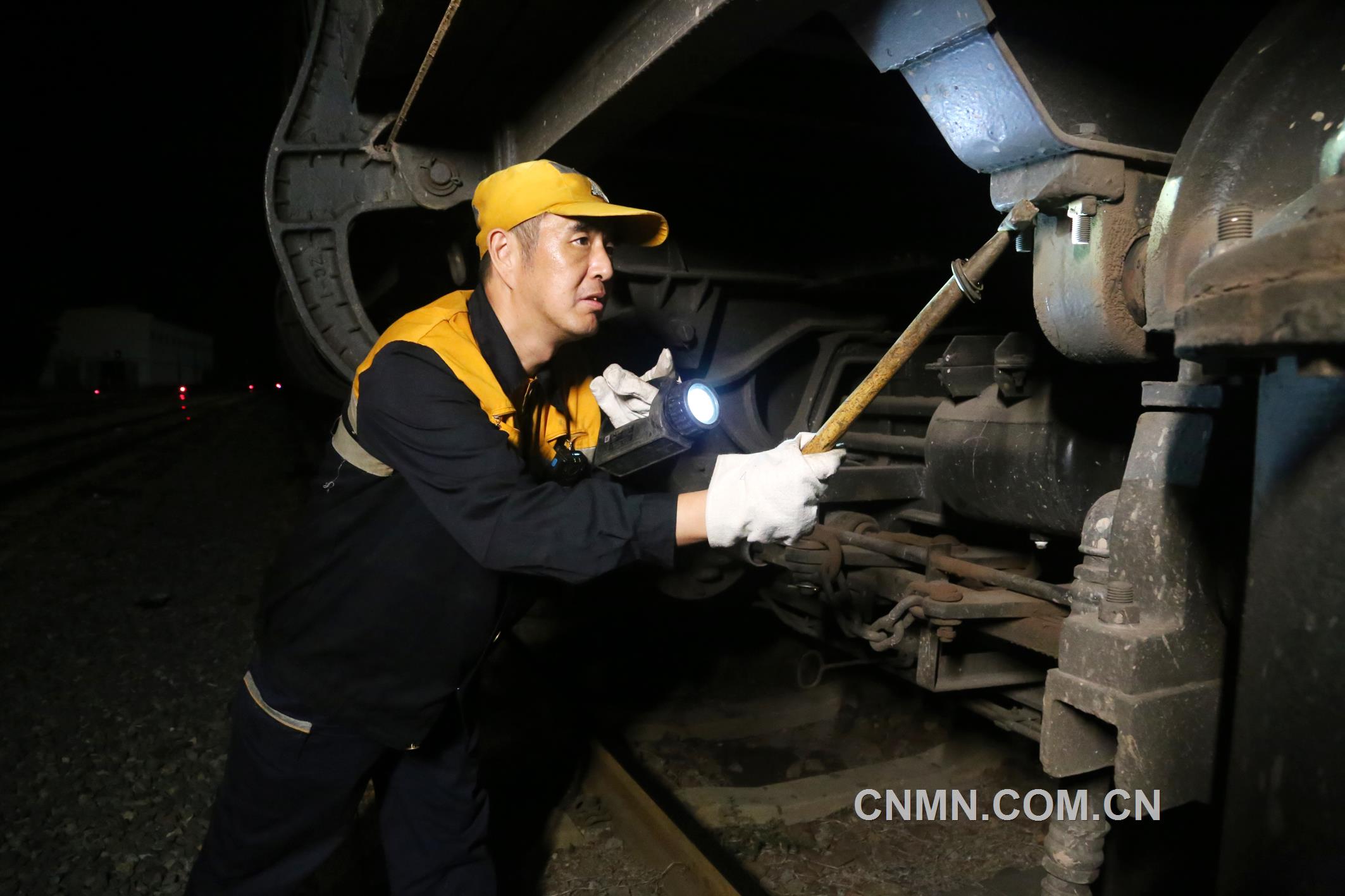 焦建智正在對待發(fā)礦石專列進(jìn)行發(fā)車前的技術(shù)檢查。